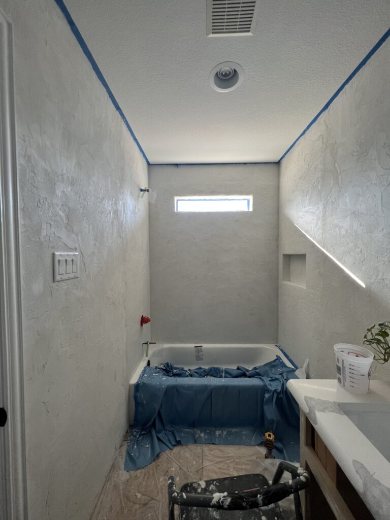 Guest bathroom walls finished with smooth microcement over Kerdi board, ready for sealing.