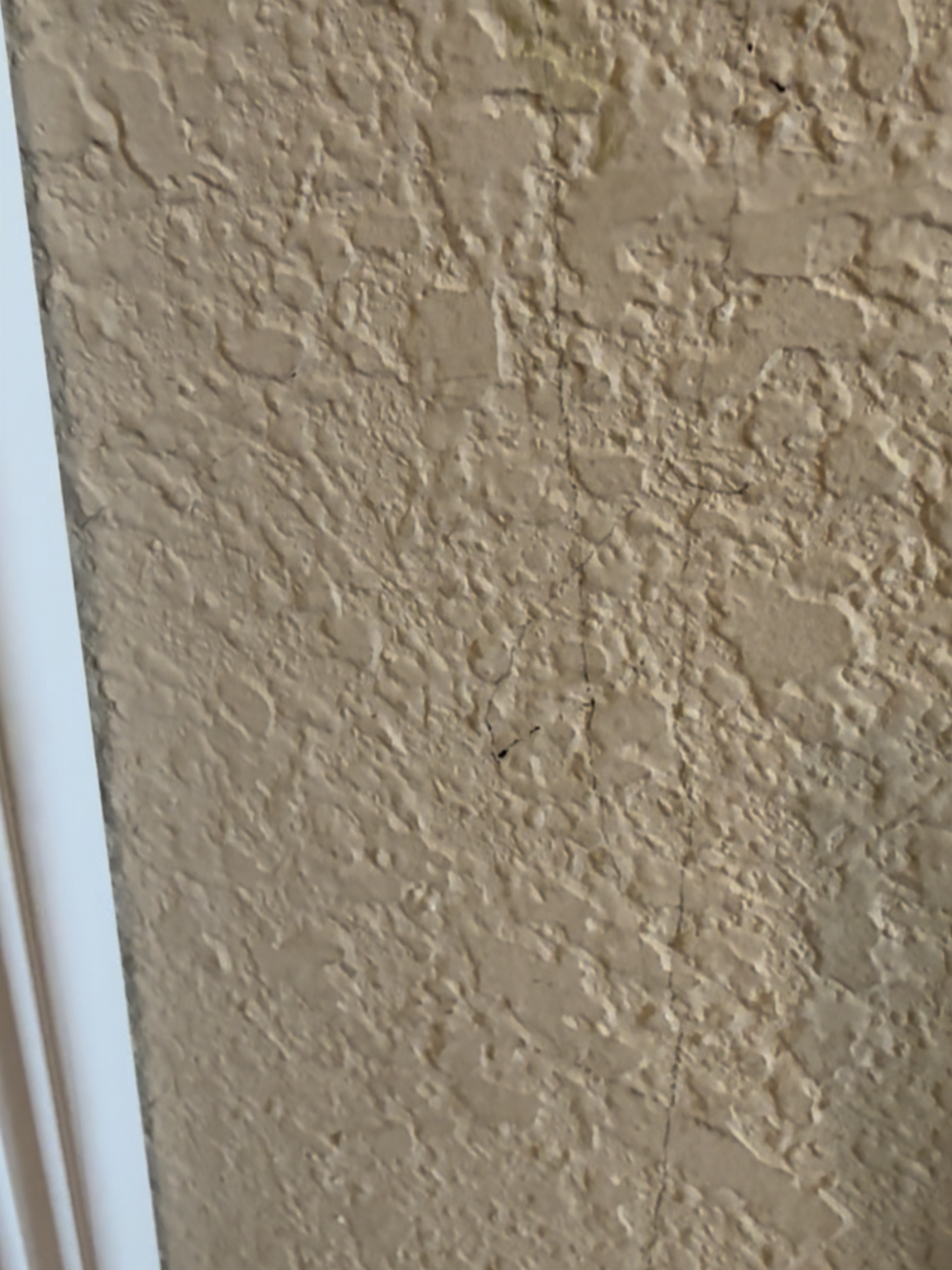 Close-up of a beige textured kitchen wall showing wear and tear before the budget kitchen glow up