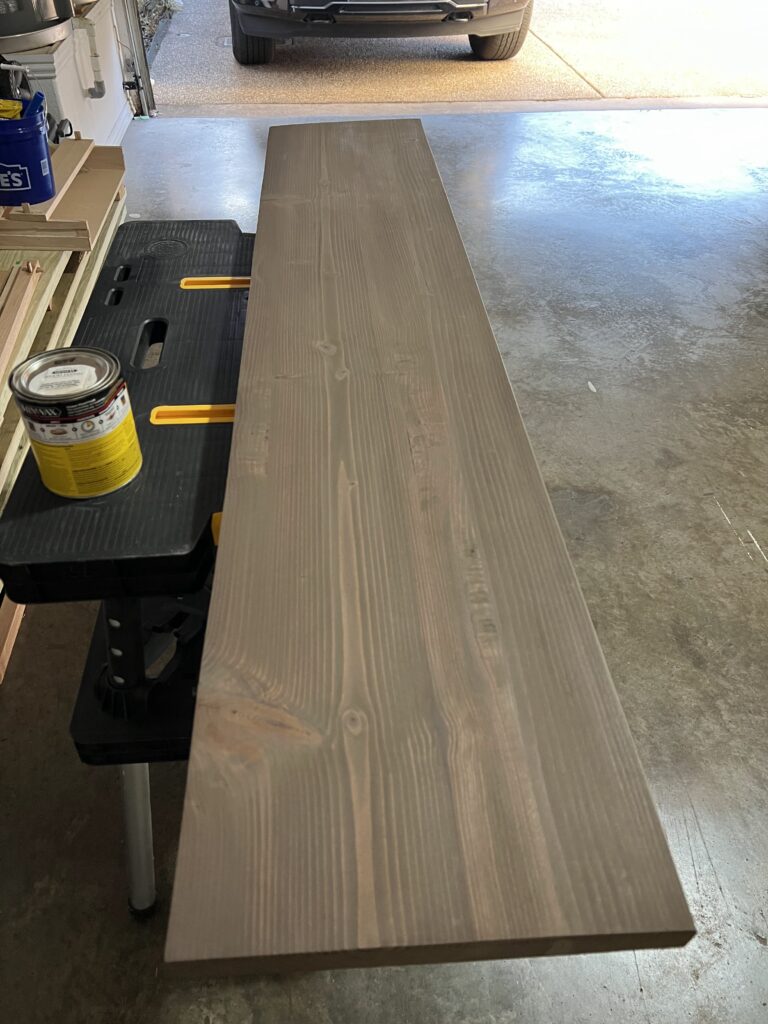 Close-up of the finished fireplace mantel showing the rich walnut wood grain and smooth satin finish.