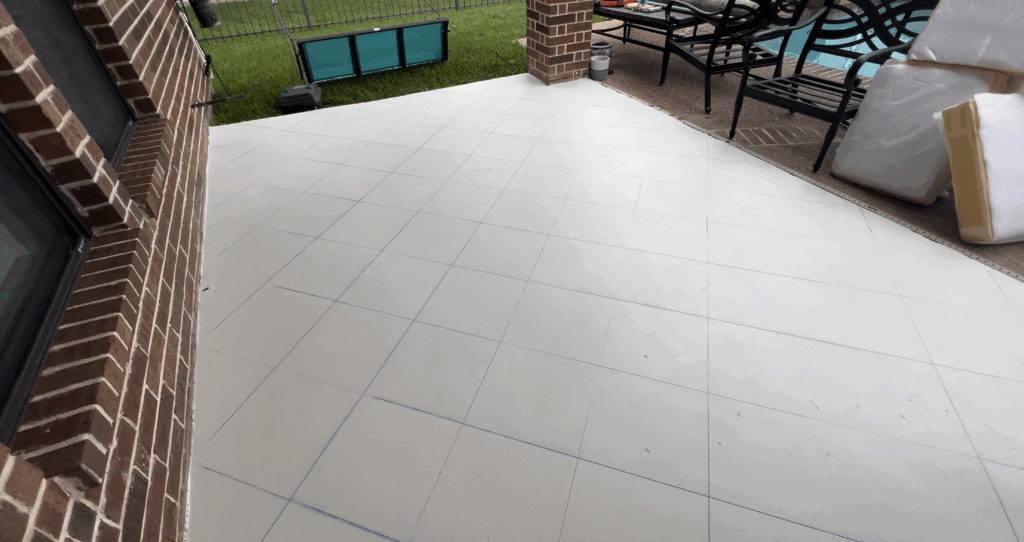 Patio floor showing blue chalk grid lines drawn for the checkerboard pattern.