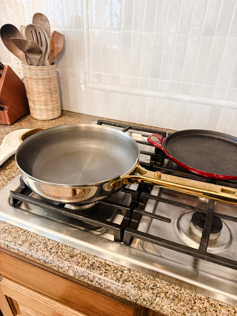 Nonstick titanium frying pan with gold handle on a gas stove, ready for cooking tofu scramble