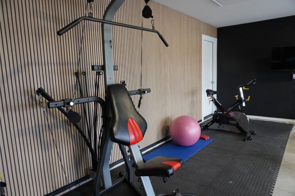 Close-up of fluted MDF panel accent wall from Lowe's installed in a home gym behind a cable weight machine
