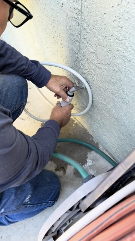 Connecting the Hoselink retractable hose reel leader hose to the outdoor water source"